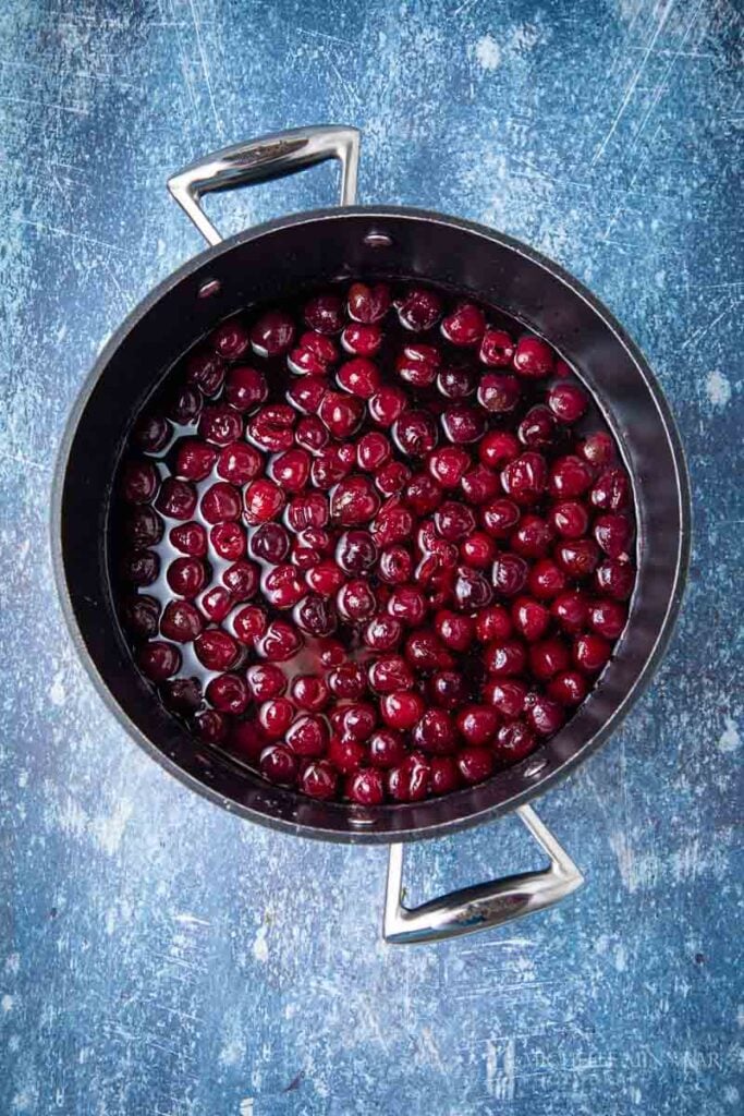 Red cherries simmering in a pot