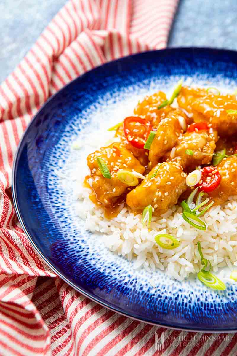 Plate of white rice topped with honey chicken chilli