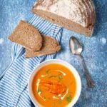 Bowl of lobster bisque and a loaf of brown bread