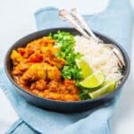 Bowl of chicken korai with white rice and limes in a bowl