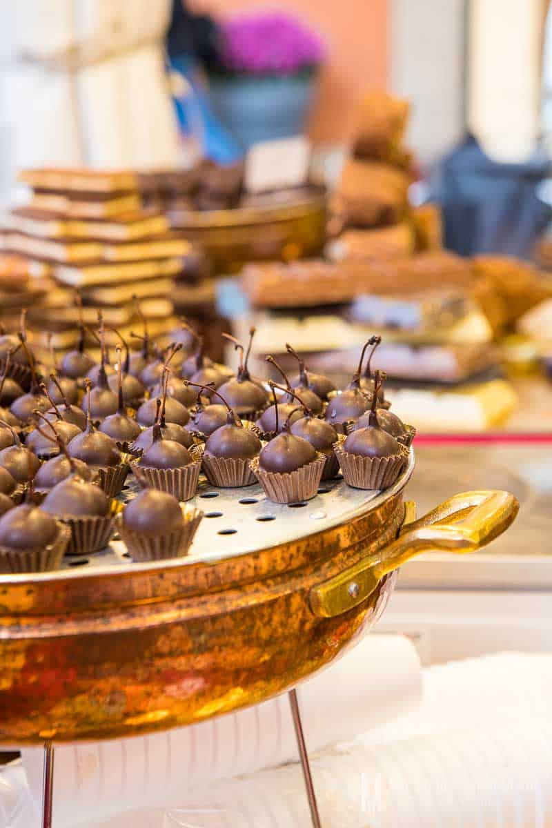 Chocolate covered cherries on copper display.