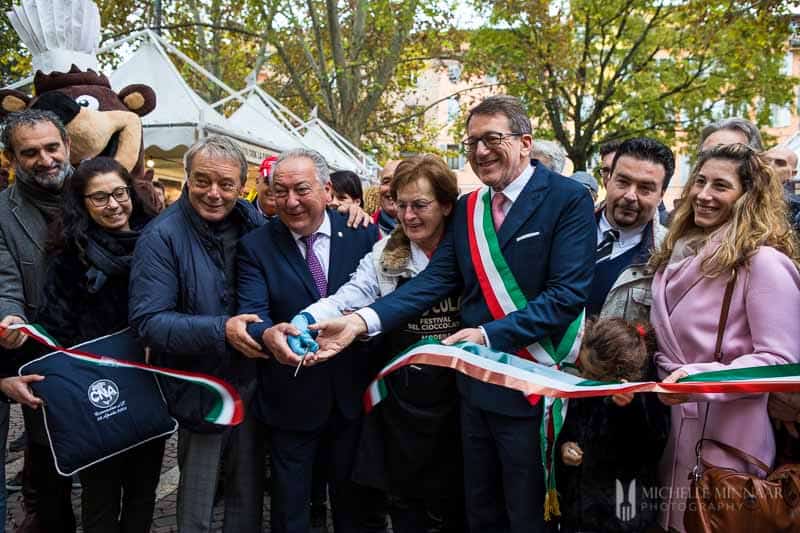 Modena's mayor cutting Sciocola's ribbon with other notable figures. 