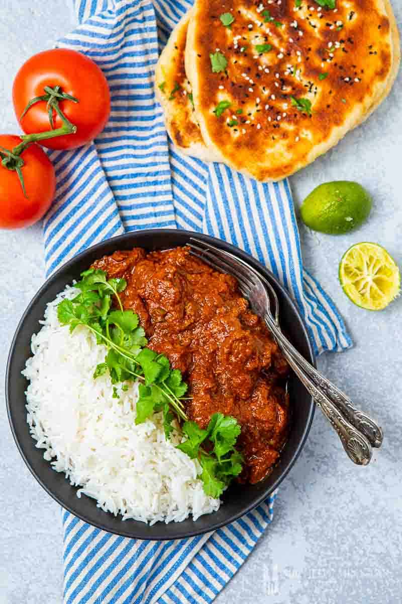 Overhead view of beef madras and white rice and naan