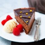 Slice of Chocolate Delice with a scoop of ice cream and fresh raspberries