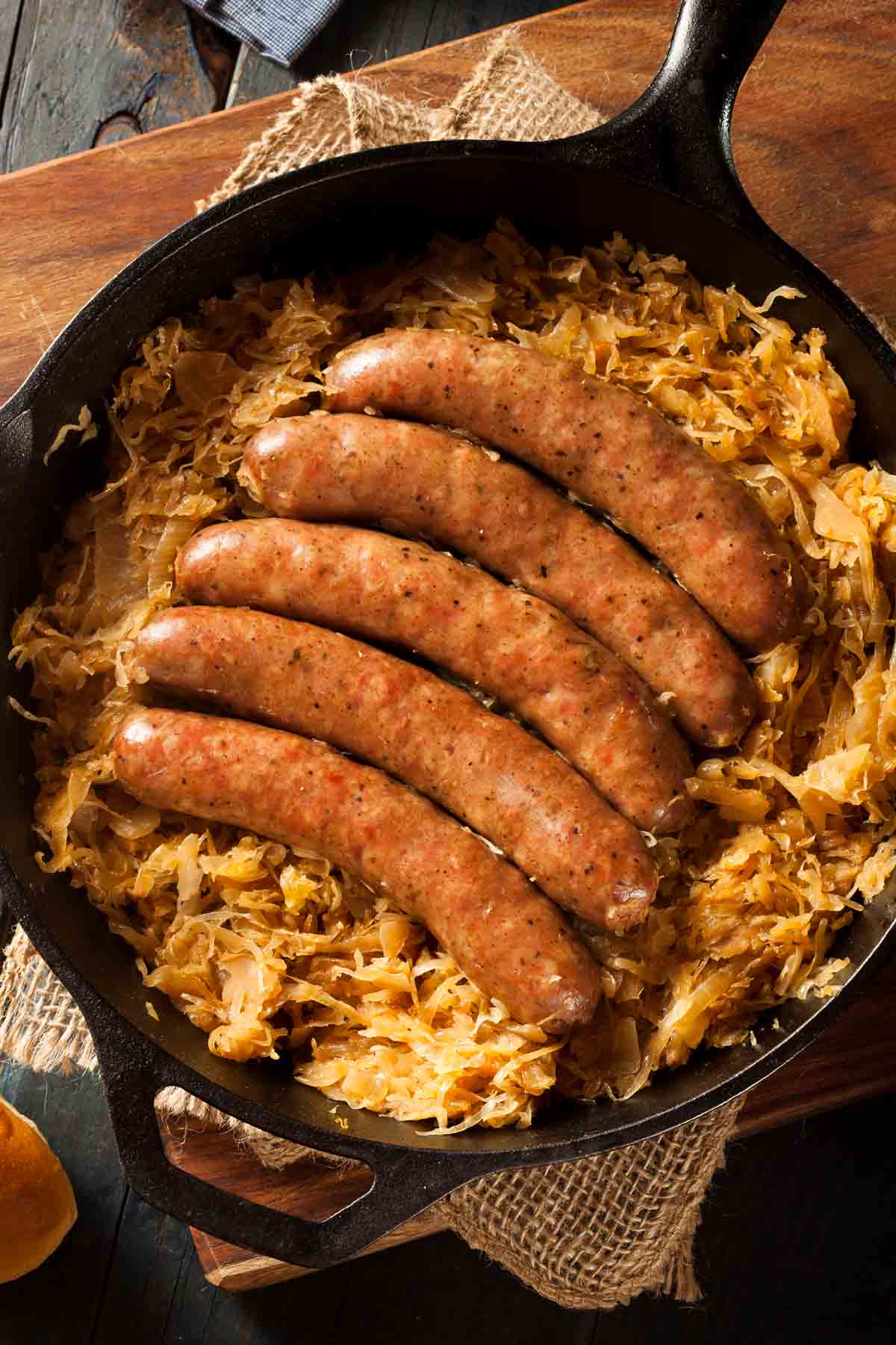 Browned German sausage over a layer of sauerkraut in a skillet