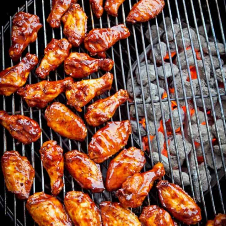 Chicken wings smothered in sauce on a bbq grill