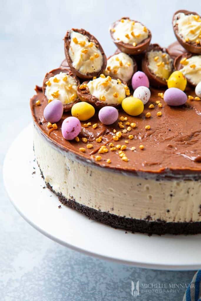Side view of layered cheesecake topped with easter eggs