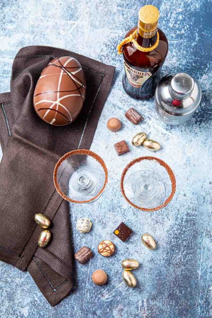 Two empty martini glasses surrounded by chocolates