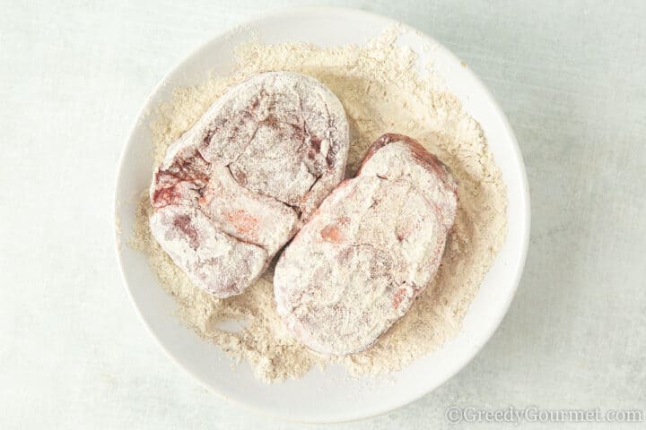 flour dusted beef shin on a white plate.