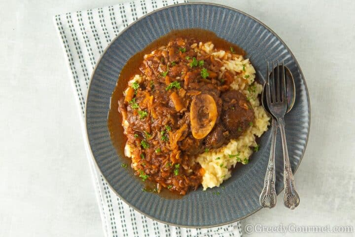 serving of Osso Buco on a blue plate.