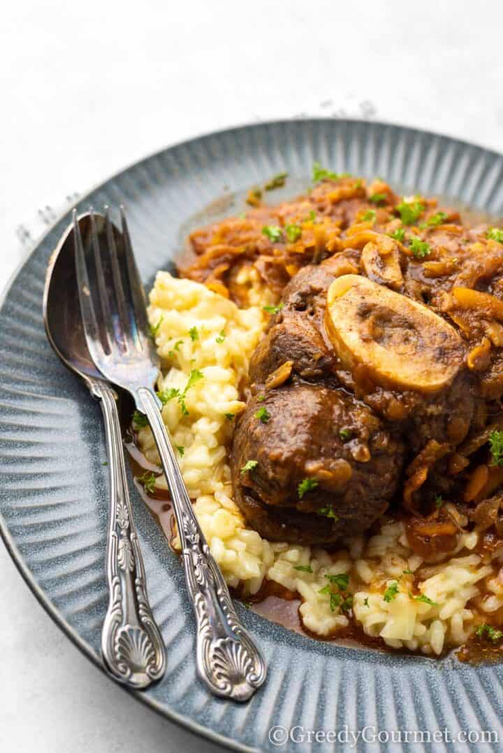 serving of Osso Buco on a blue plate.