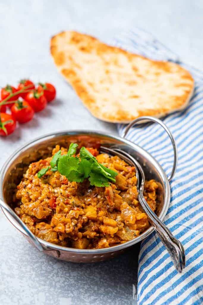 Bowl of brinjal bhaji and naan bread