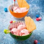 Two bowls of pink ice cream with wafers