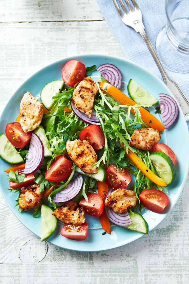 Plate of chicken and tomatoes on lettuce