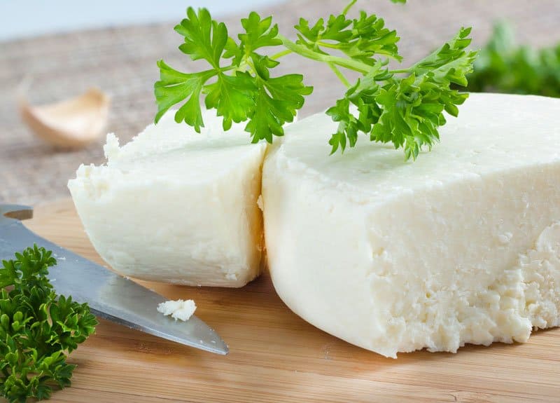 White chunk of cotija cheese with parsley.