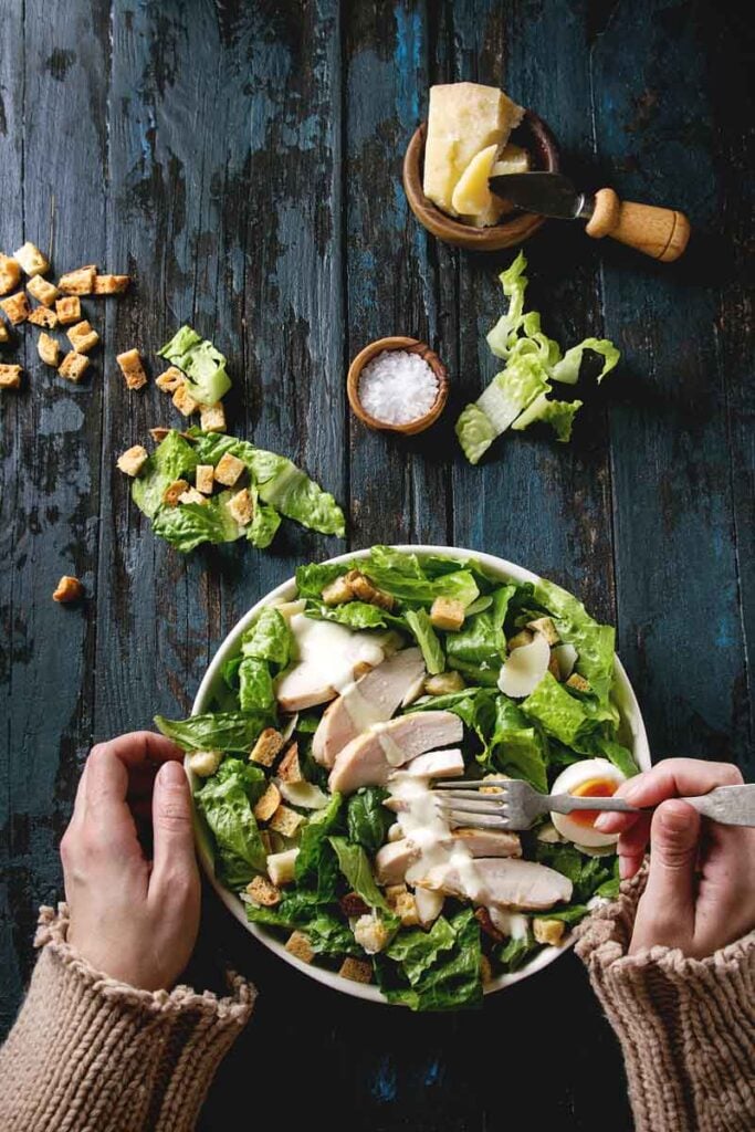 Two hands making a chicken salad 