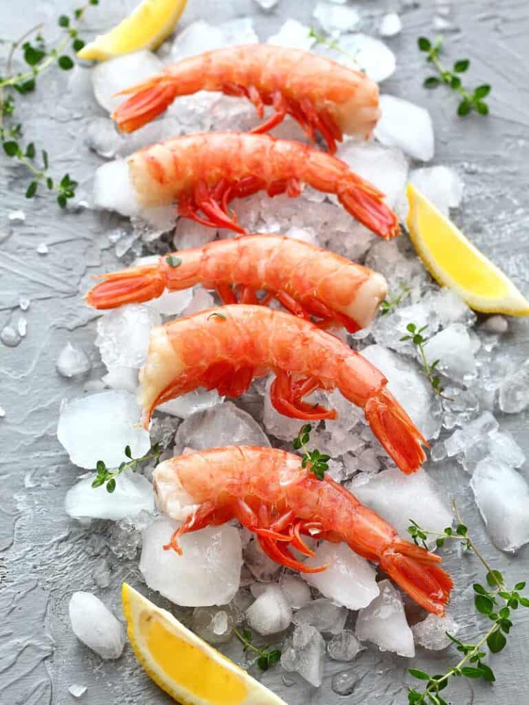 Red prawns on ice with lemon wedges 