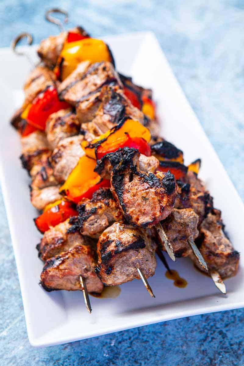 Plate of lamb and peppers on skewers