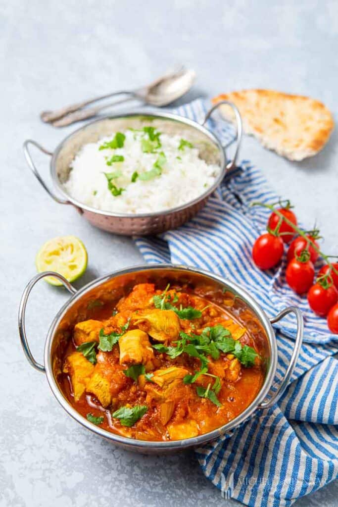 Bowl of chicken pathia and Indian sides