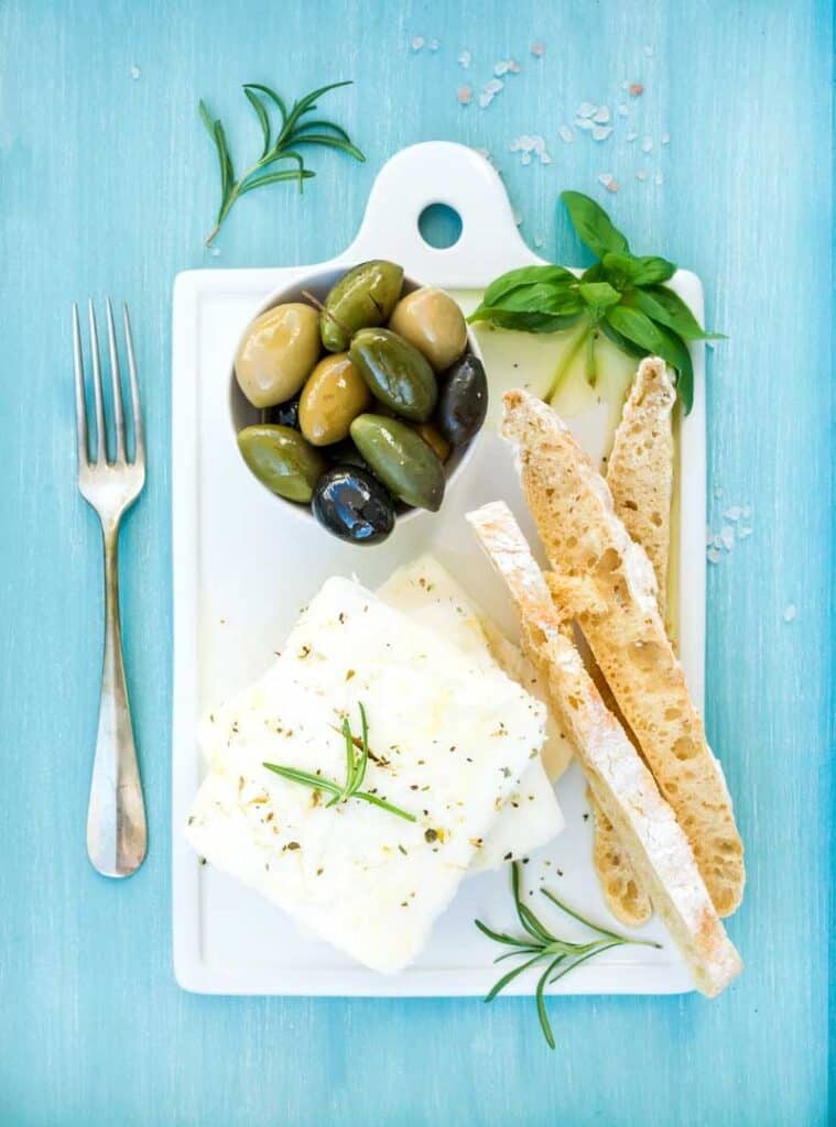 Large white block of feta cheese and breadsticks