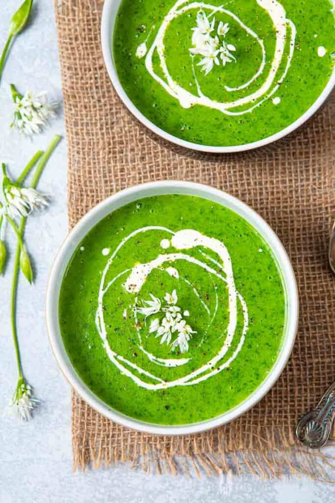Close up of two bowls of green soup 