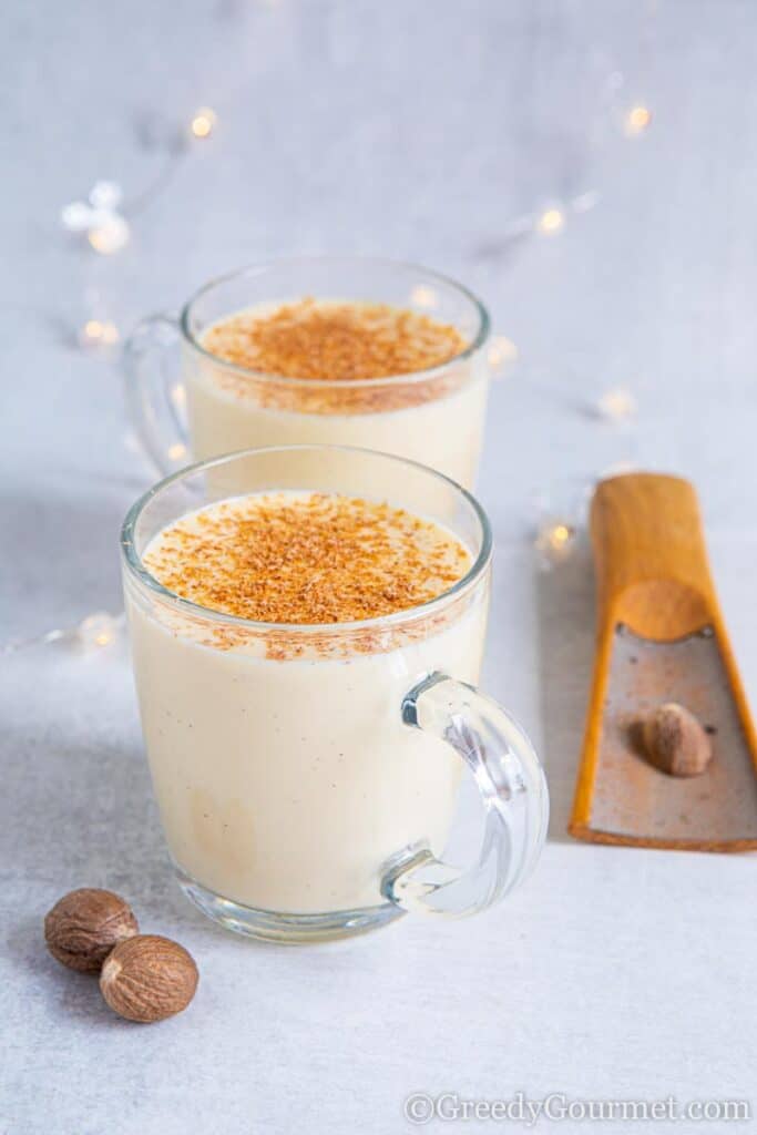 Two glass mugs of boiled custard with nutmeg