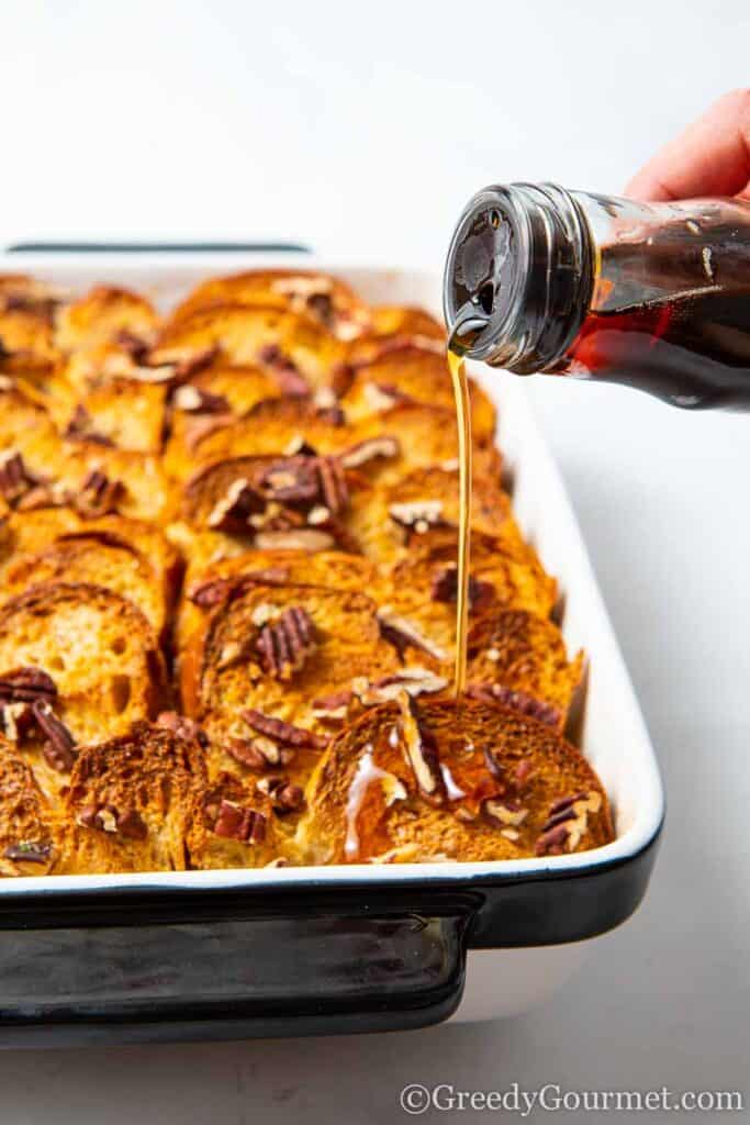 Syrup being poured onto a baked French toast casserole