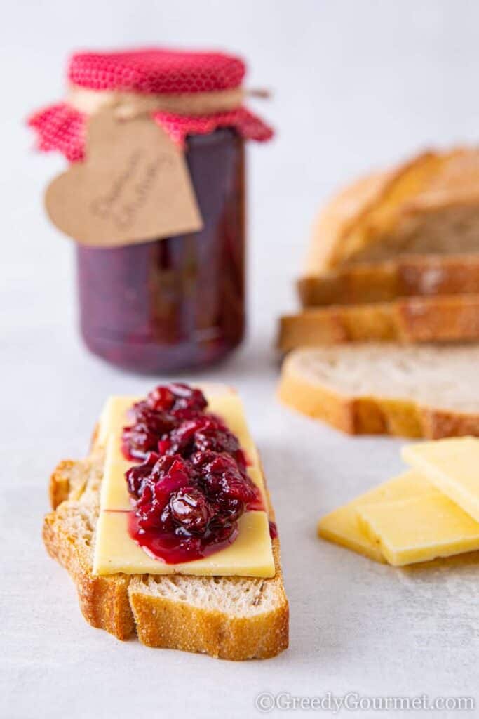 Jay of damson chutney with a slice of bread and cheese smothered in damson chutney