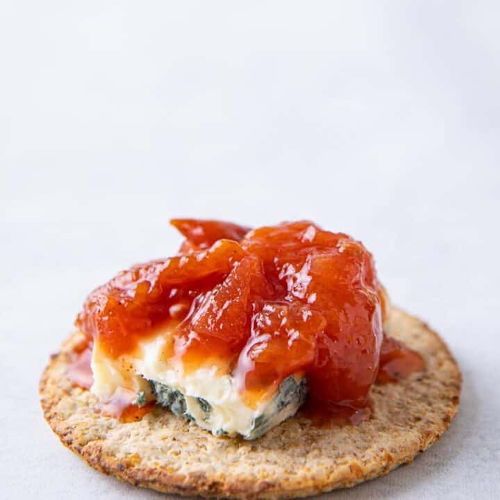 Cracker topped with blue cheese and a spiced plum chutney
