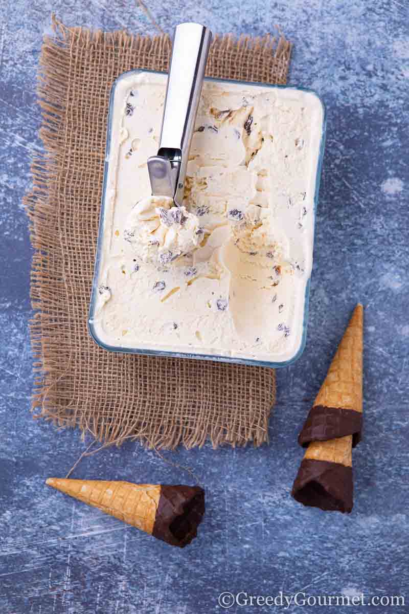 Fresh raisin ice cream in a glass container and ice cream cones