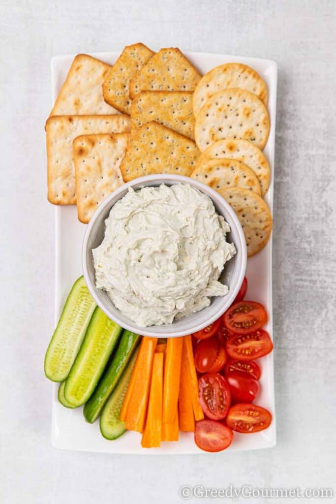 Bowl of white vegetarian dip recipe and crackers with vegetables