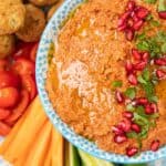 Bowl of bright orange muhammara (roasted red pepper dip)