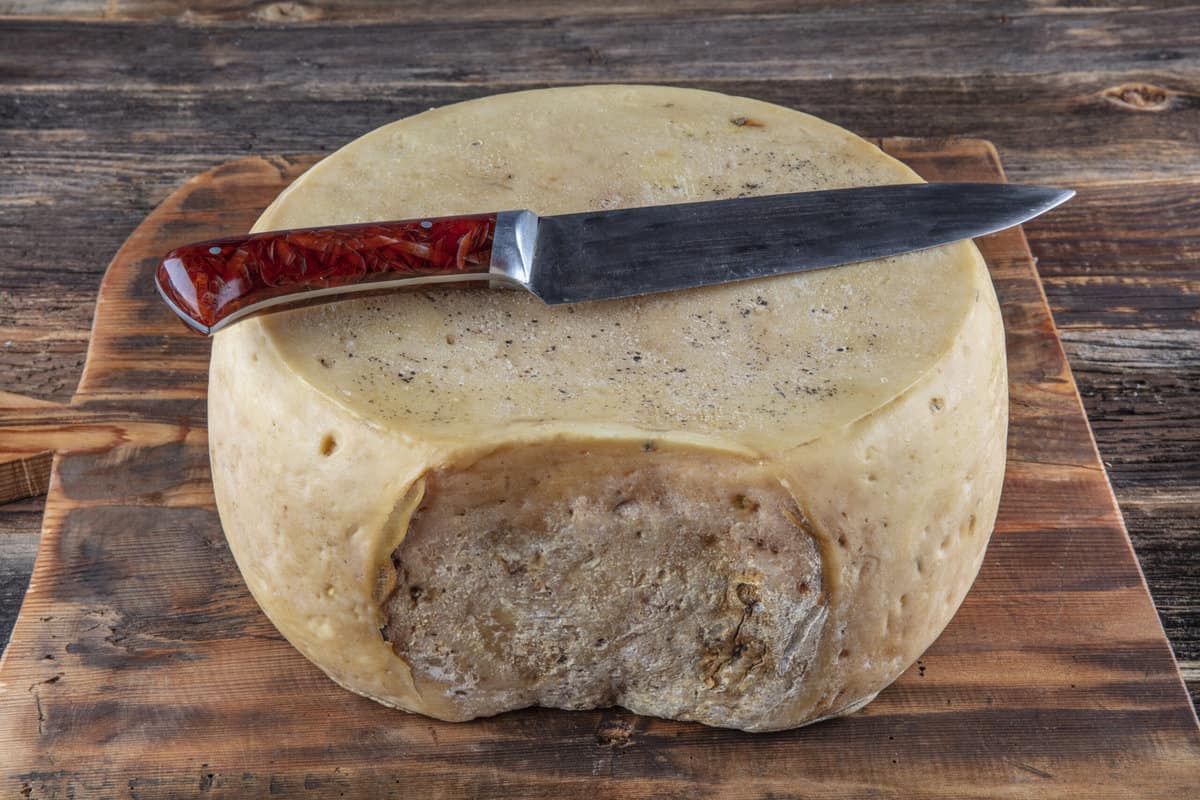Block of round Kars gravyer cheese with a knife
