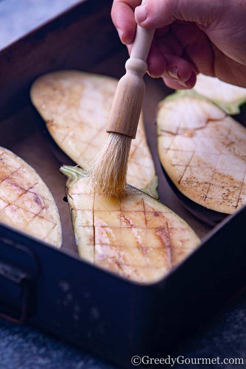 Oil being brushed onto eggplant