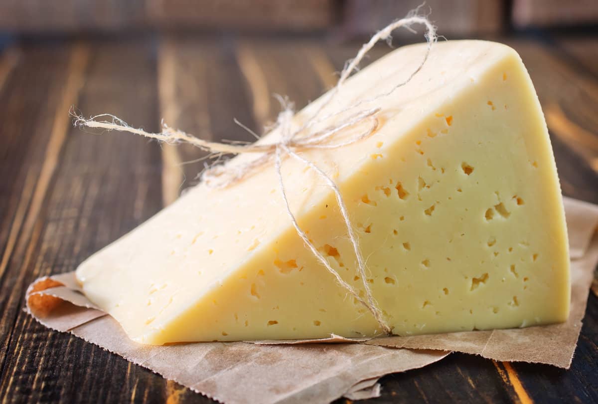 Le Brouere cheese on the wooden board and on a table