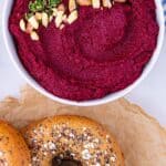 Bowl of beetroot hummus and a bagel