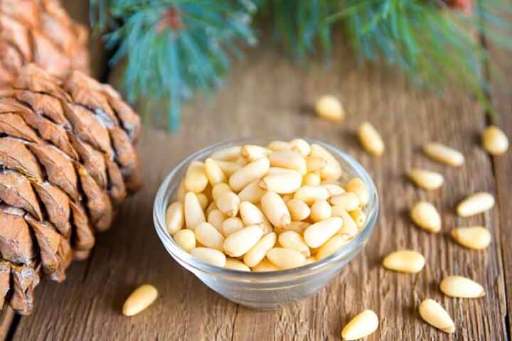 Glass bowl of whole pine nuts