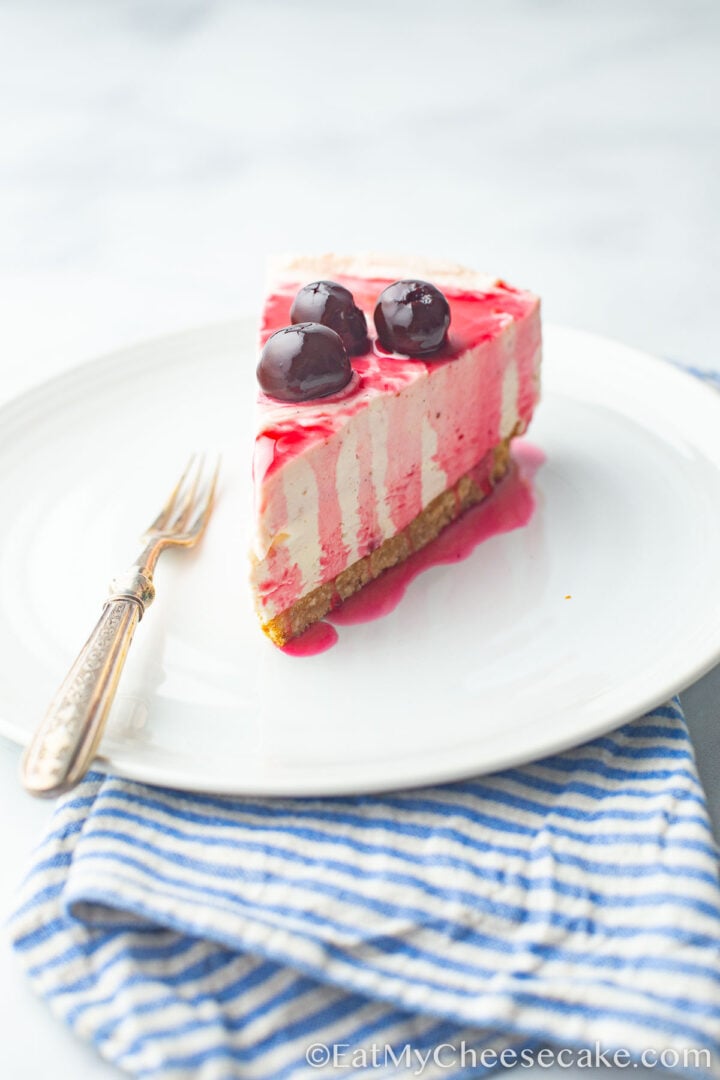 Cherry cheesecake and a fork on a plate.