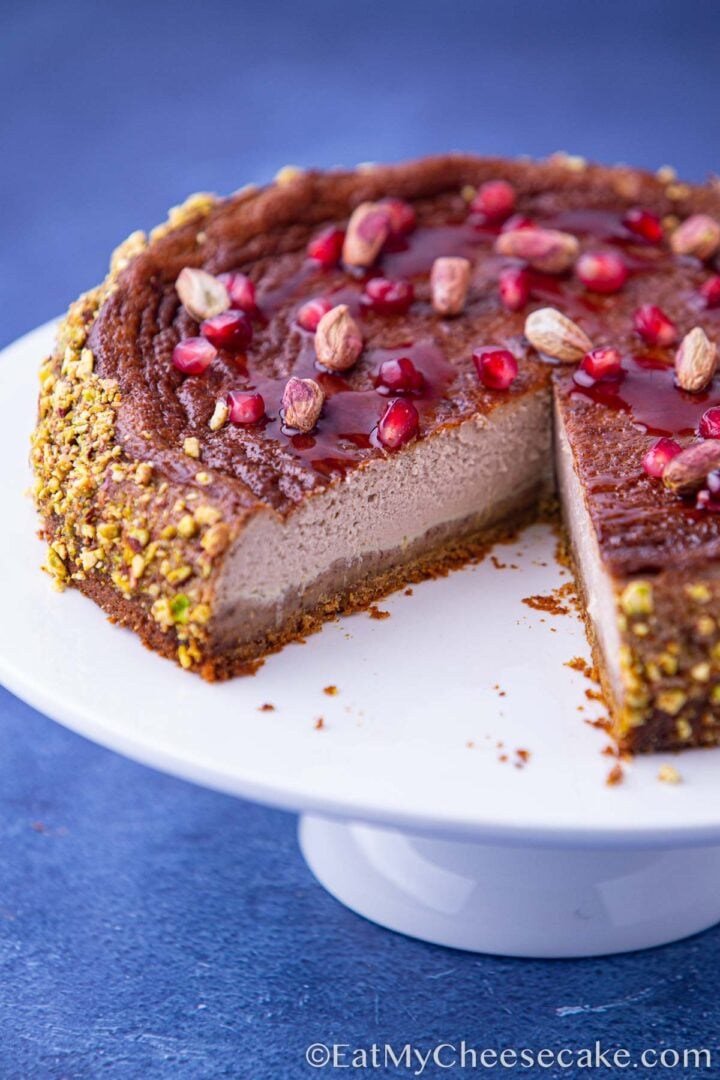 Baked pomegranate cheesecake with a slice taken out.