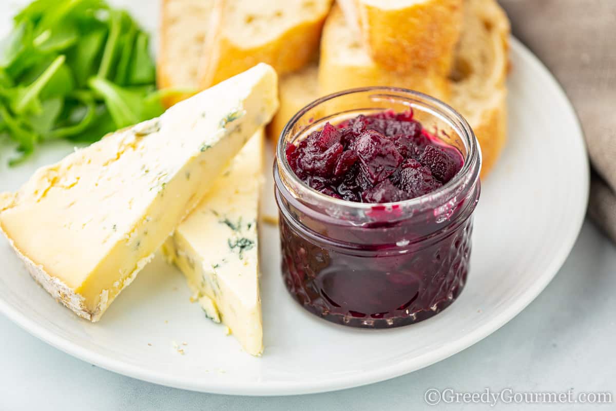 Close up of a purple chutney and slices of cheese.