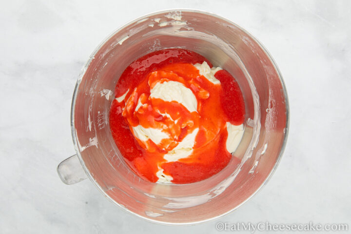 Whipped cream and strawberry sauce in a bowl.