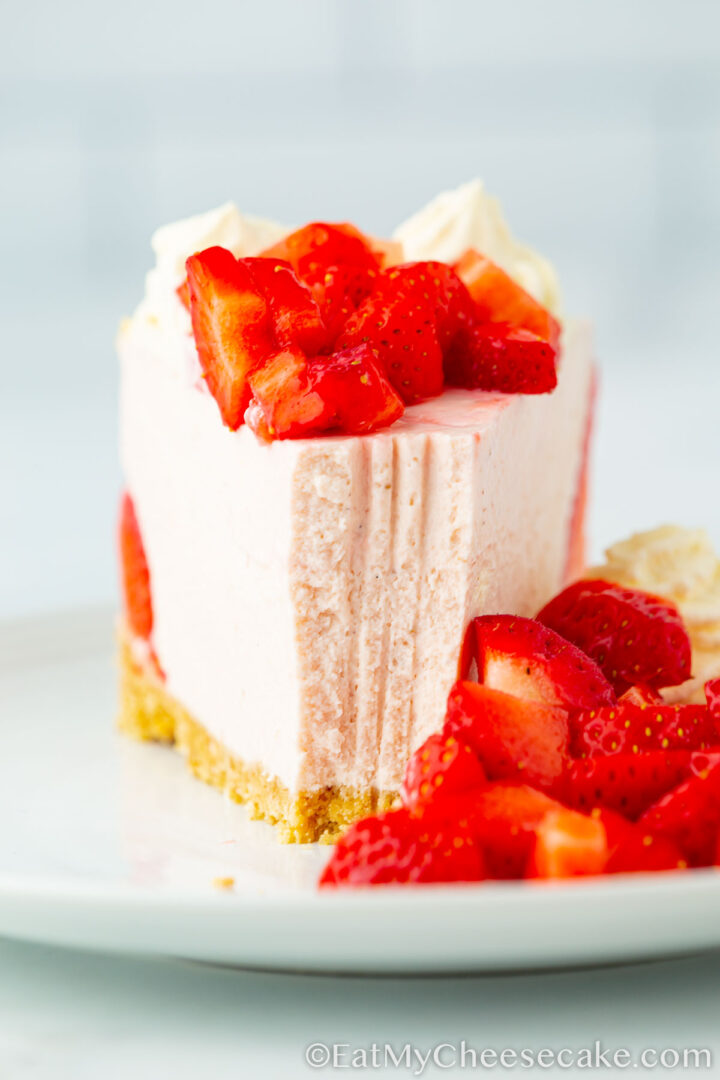 Slice of cheesecake with fresh strawberries on a plate.