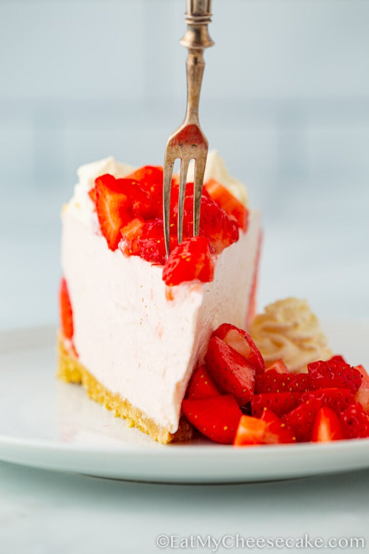 Slice of cheesecake with fresh strawberries.