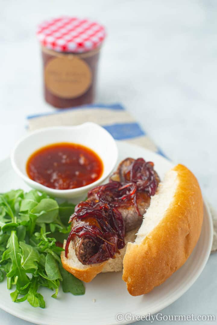 Mrs Balls Chutney in small bowl next to hot dog in bun with salad