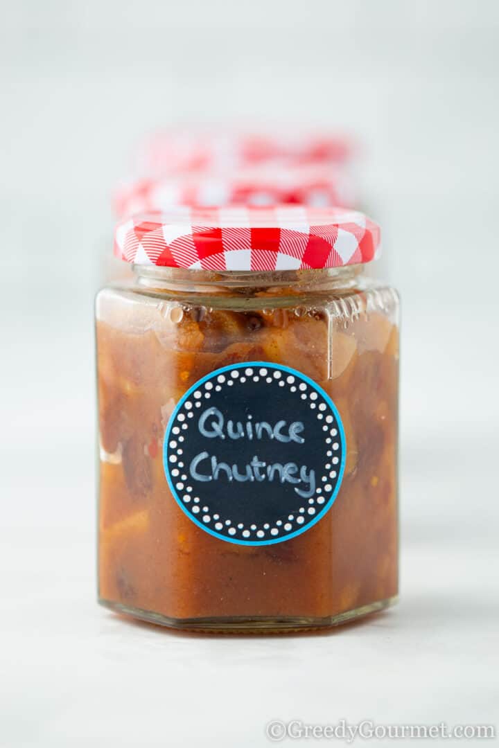 Quince chutney in a labelled glass gar.