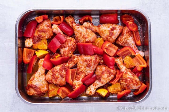 Chicken in dish with peppers ready for the oven