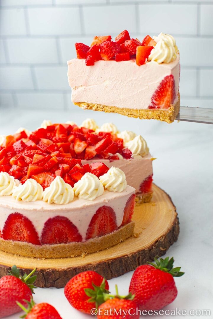 Strawberry cheesecake with fresh strawberries on a wood serving board.
