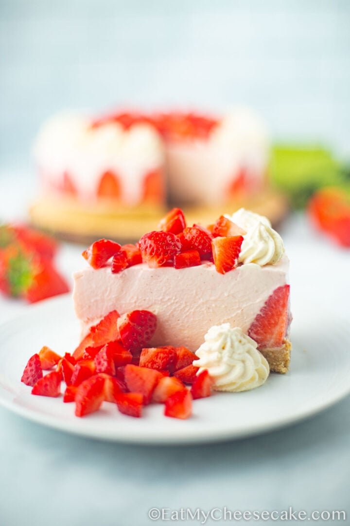Slice of cheesecake with fresh strawberries on a plate.