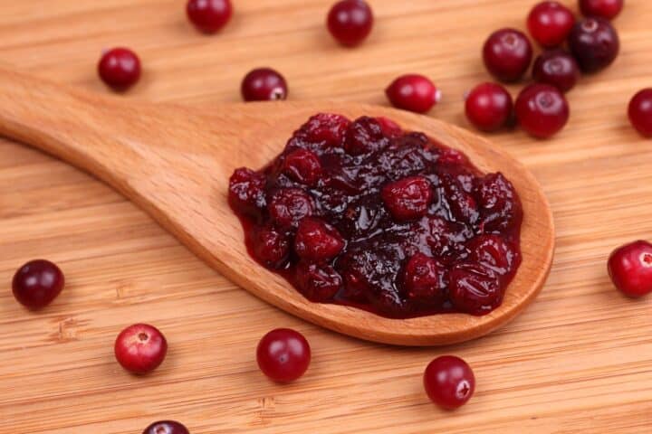Spoonful of cranberry sauce surrounded by cranberries
