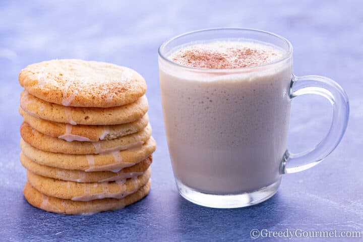 Almond milk smoothie in glass alongside almond cookies